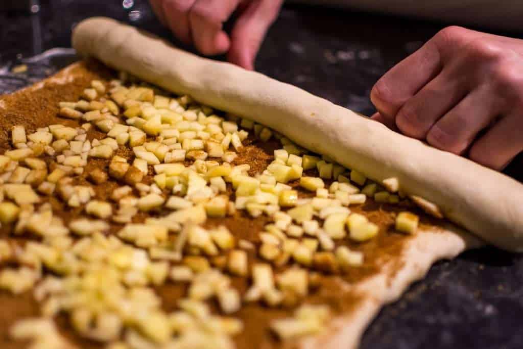 Rolling the cinnamon apple filling dough into a log.