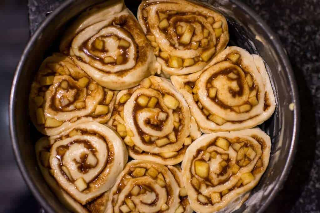 Sourdough apple cinnamon rolls aranged in a cake tin.