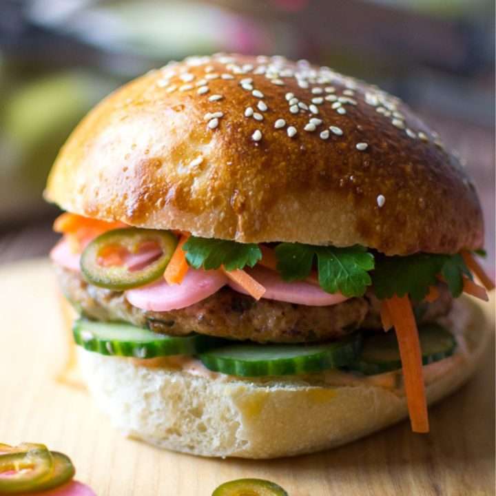 Vietnamese Pork burger with pickled vegetables on a wooden board.