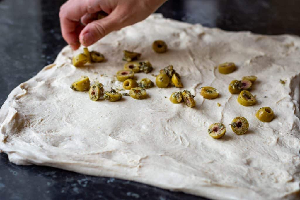 Laminating roasted garlic green olives into sourdough.