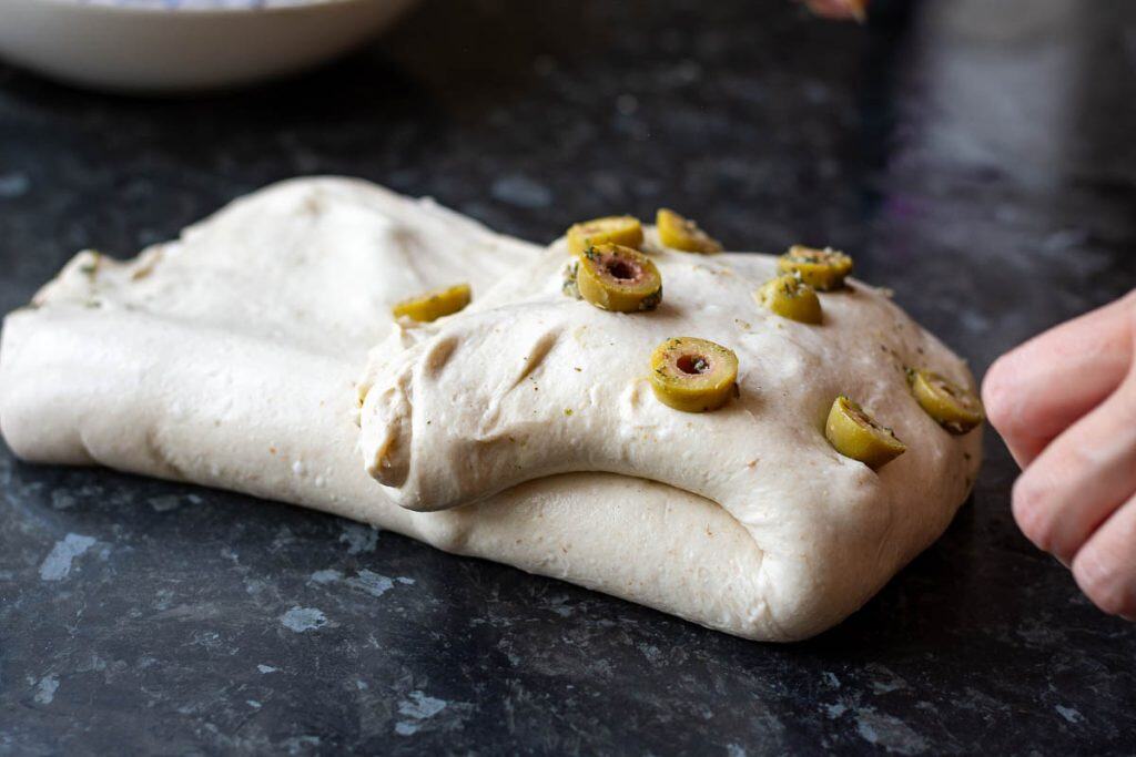Laminating roasted garlic green olives into sourdough.