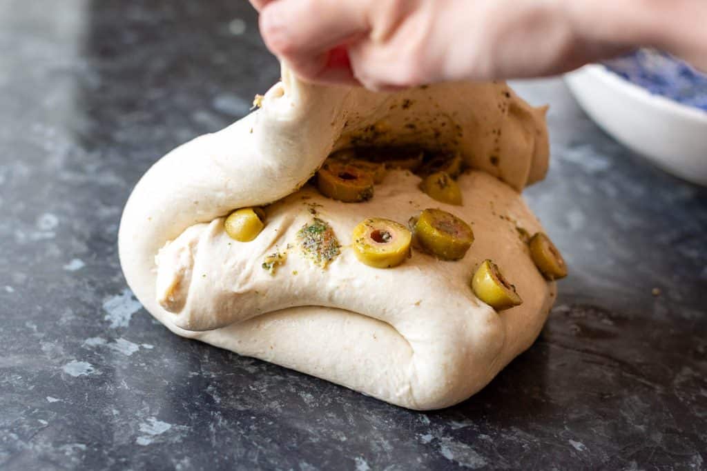 Laminating roasted garlic green olives into sourdough.