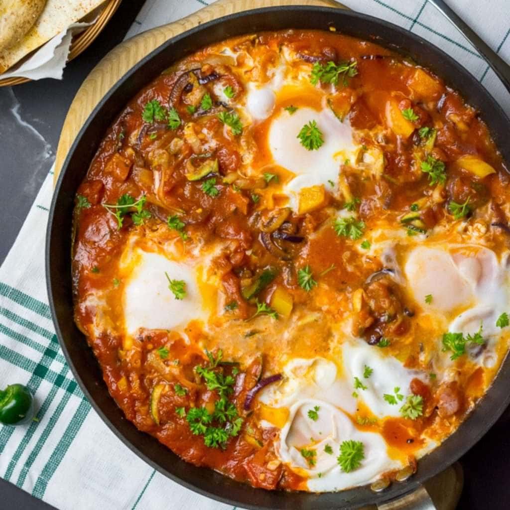 Huevos rancheros with chorizo in a large frying pan.