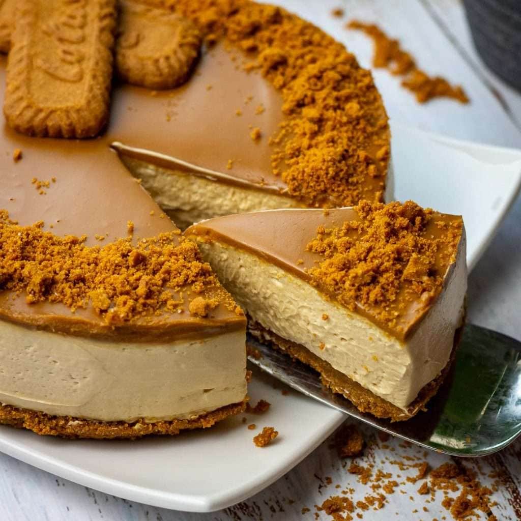 A slice of biscoff cheesecake being cut.