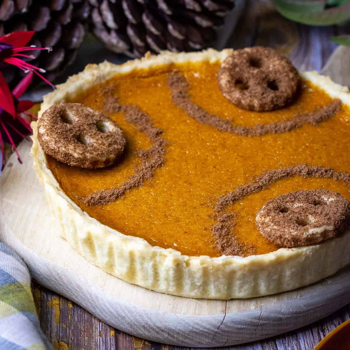 Homemade pumpkin pie without evaporated milk decorated with sices and pastry cookies coated in cinnamon sugar.