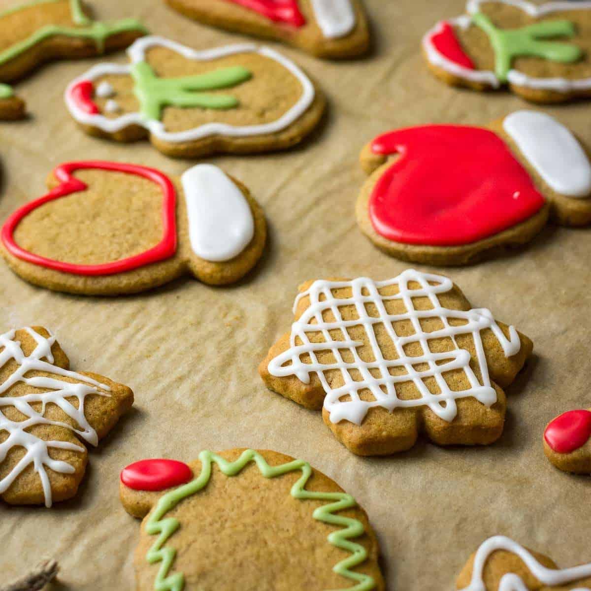 Sourdough gingerbread cookies decorated with icing sugar on a baking parchment sheet.