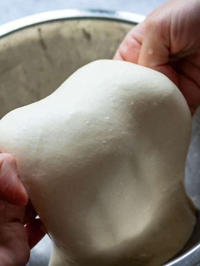 Coil fold of sourdough ciabatta dough in a metal bowl.