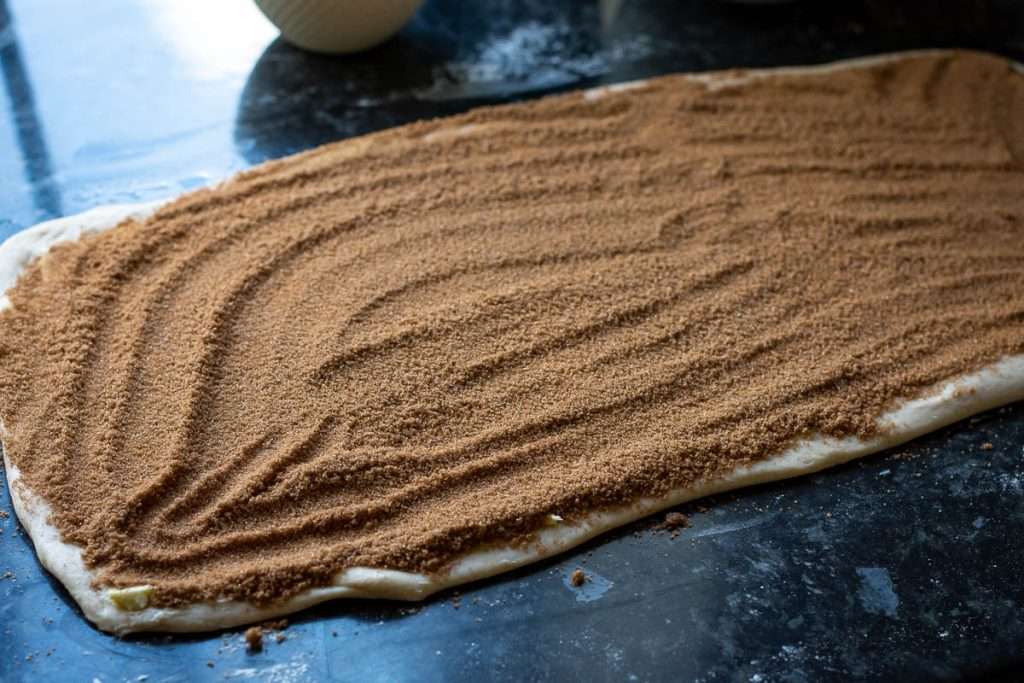 Cinnamon sugar spread on the dough with butter,