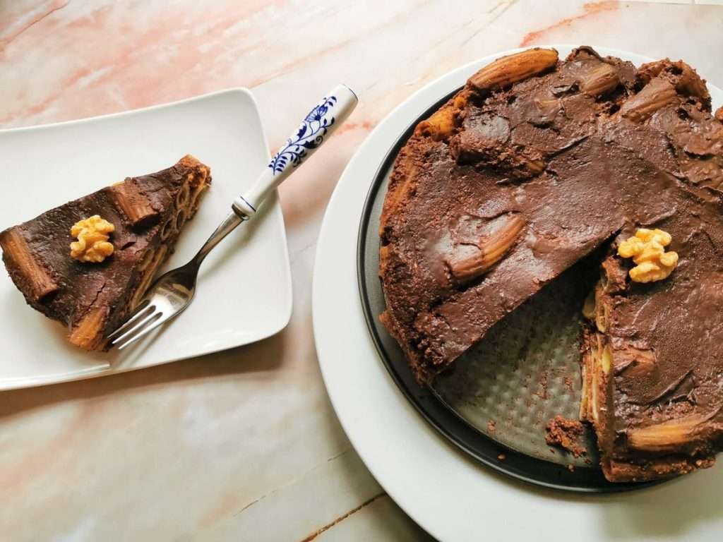 Sweet Chocolate Pasta Dessert in a shape of a cake, with one slice cut onto a square white plate.
