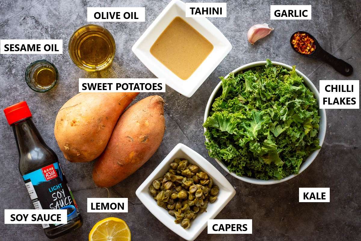 Ingredients for warm sweet potato and kale salad with tahini dressing on a grey surface.