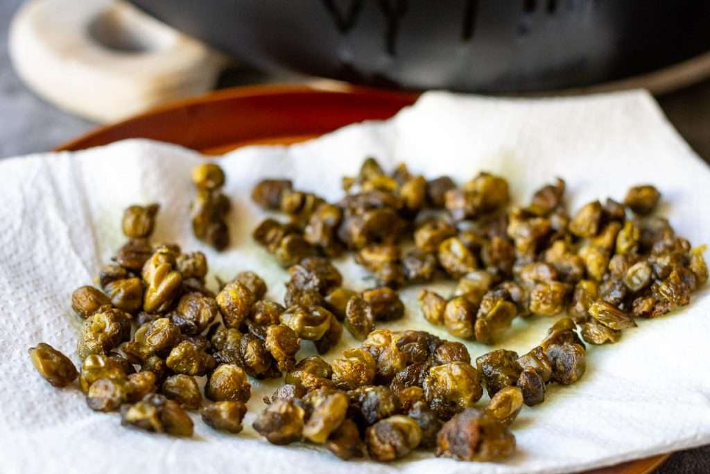 Crispy capers on a paper towel lined plate.