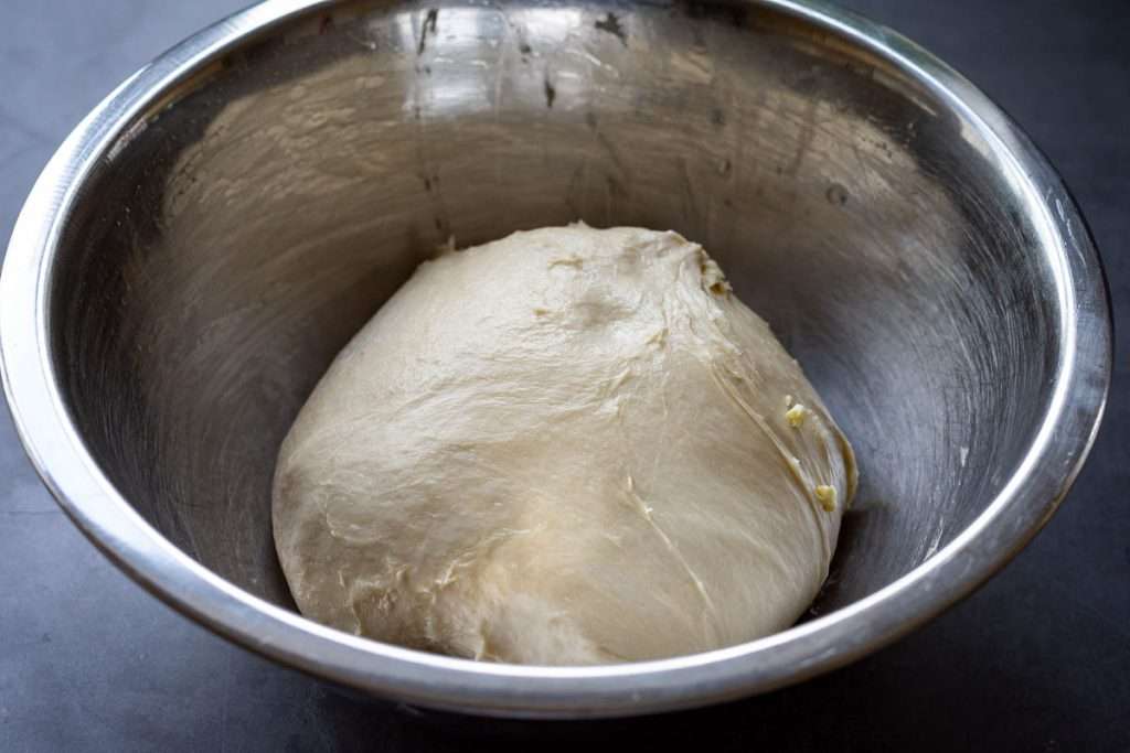A Ball of sourdough in a metal mixing bowl.