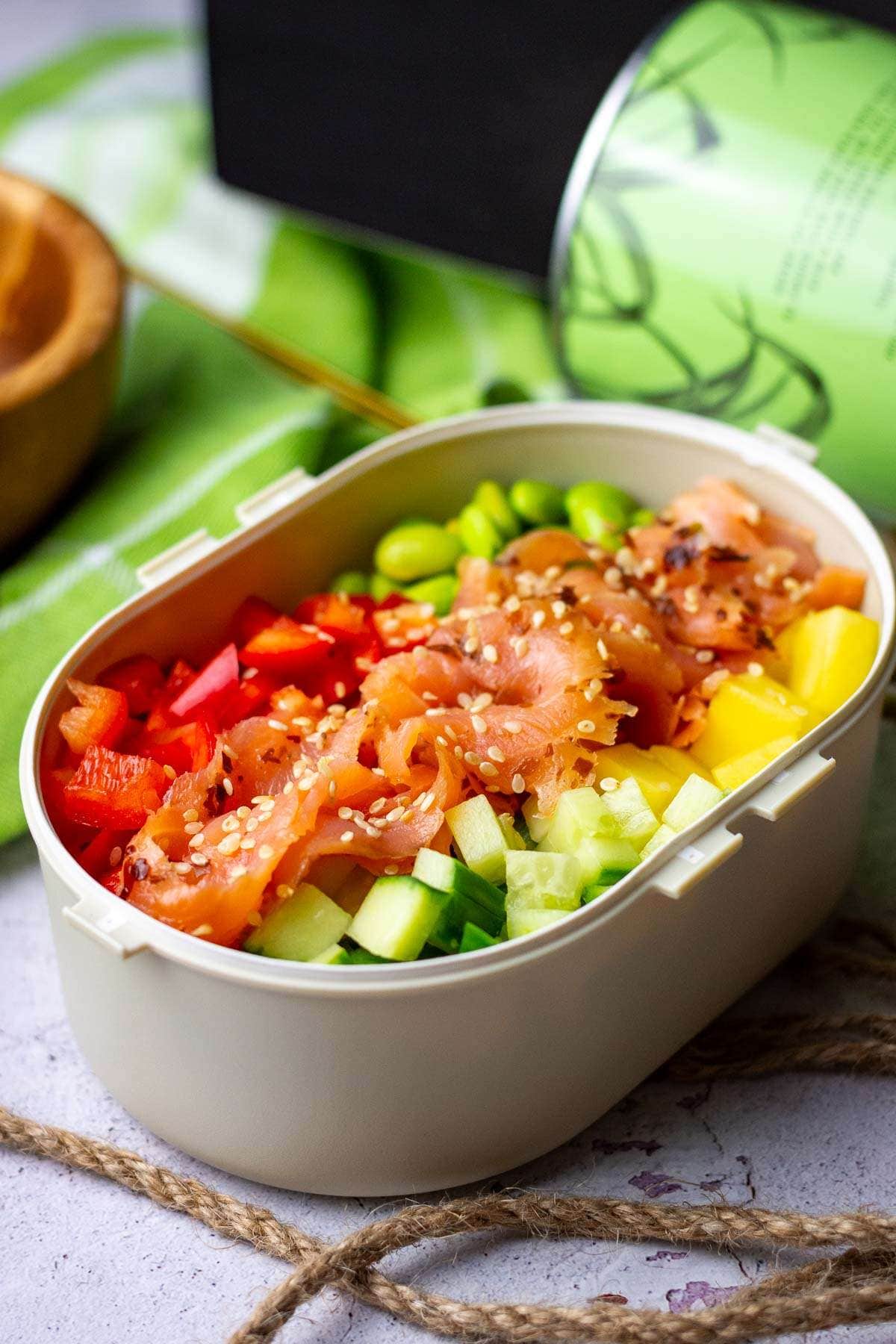 Smoked salmon poke bowl packed into an airtight container for an office lunch.