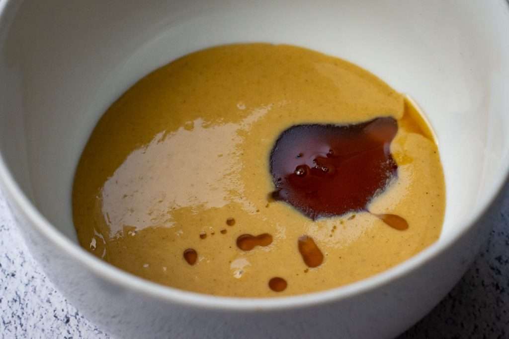 Tahini, maple syrup and salt in a small white bowl.