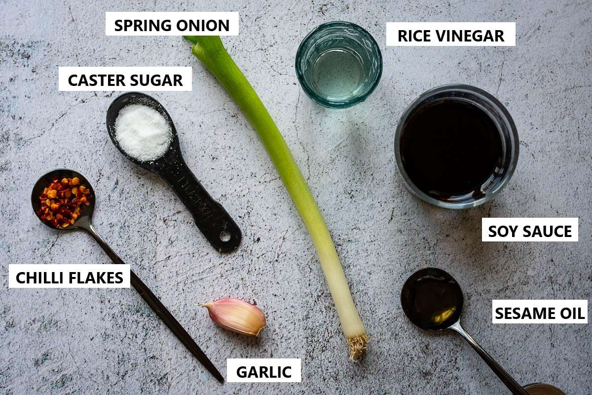 Ingredients for gyoza dipping sauce on a light grey surface.