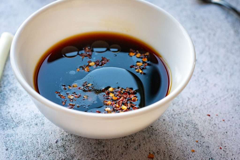 Wet ingredients for the gyoza sauce in a small white bowl.