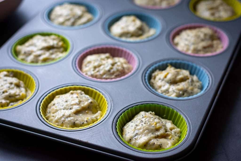 Sourdough discard muffin batter divided between 12-hole muffin tin holes.
