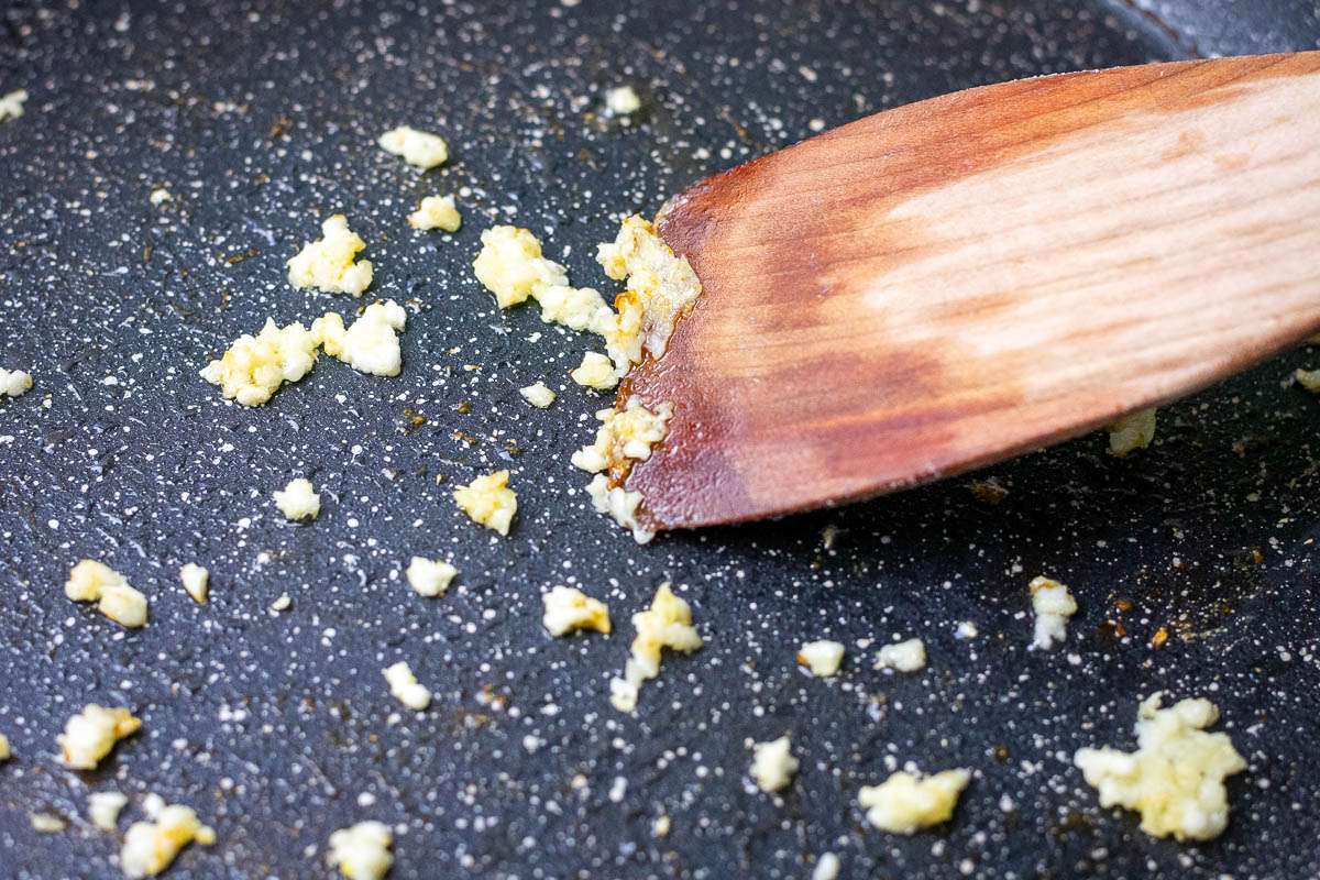 Frying garlic in a large hot pan with oil.