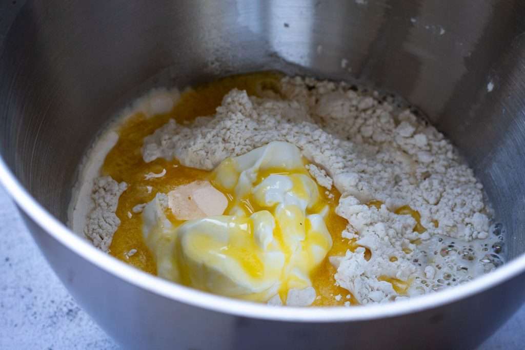 All naan dough ingredients in a large metal bowl.