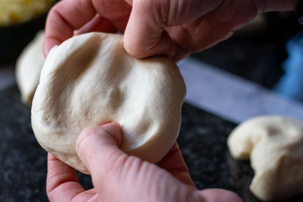 Streatching the dough out into a circle.