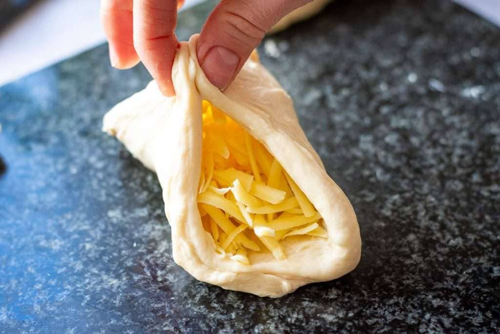 Encasing cheese into the naan dough.