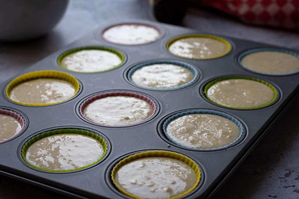Sourdough batter divided into 12 hole muffin tin.