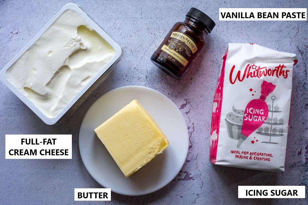 Vanilla Cream Cheese Fristing Ingredients for cupcakes on a light grey surface.