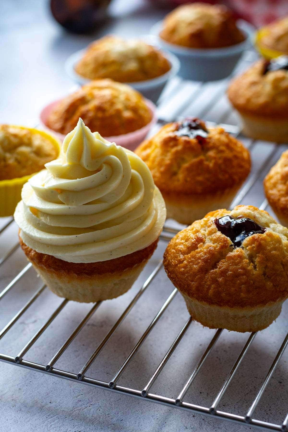 A bunch of sourdough cupcakes hollowed and filled with cherry jam and iced with cream cheese frosting.