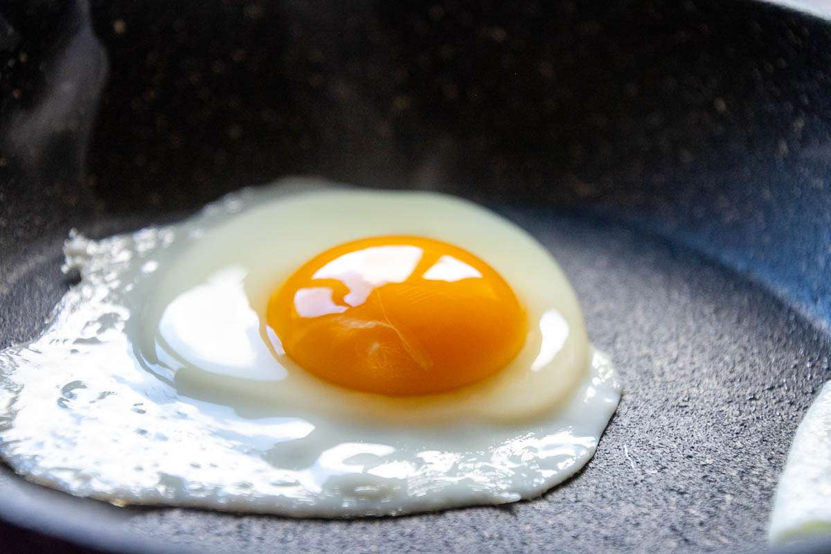 An egg frying in a pan.