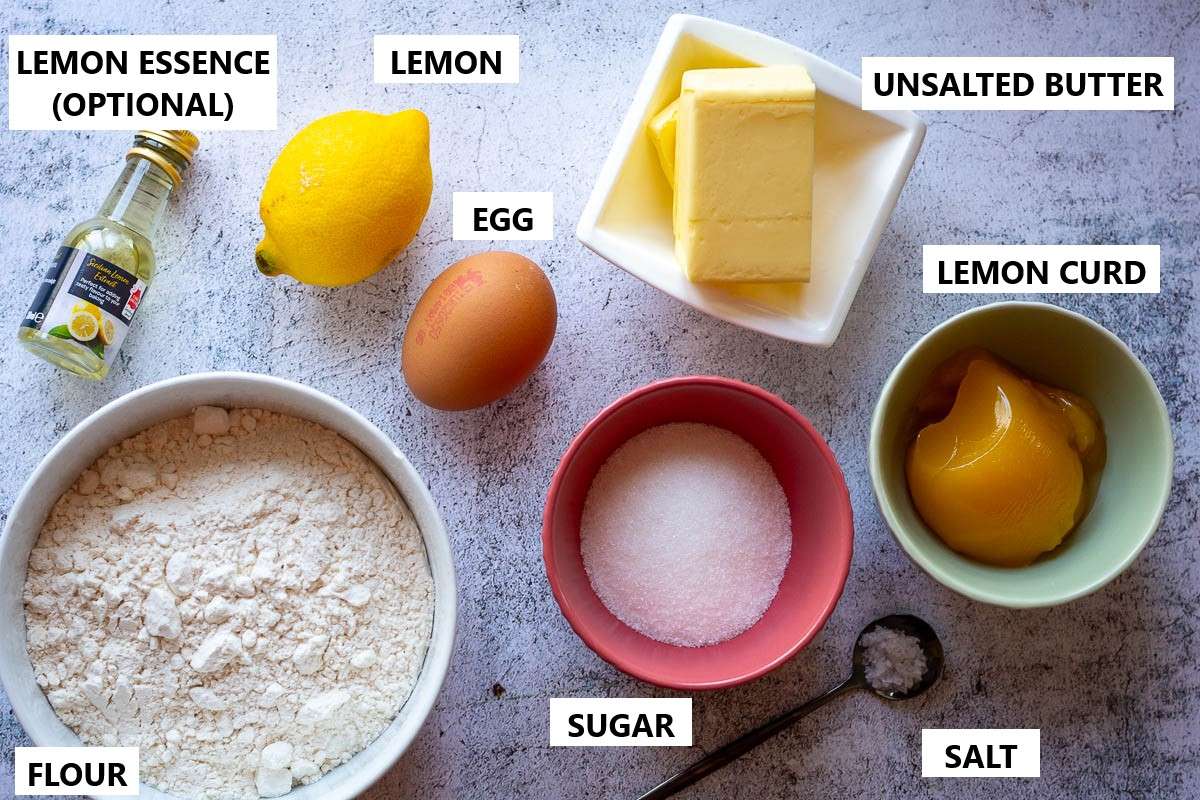 Ingredients for Lemon Thumbprint Cookies With Lemon Curd on light grey surface.