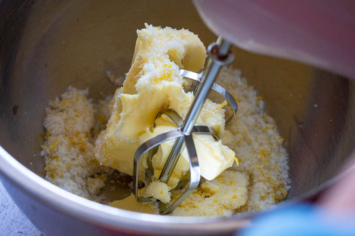 Beating lemon sugar and butter with a handheld mixer.