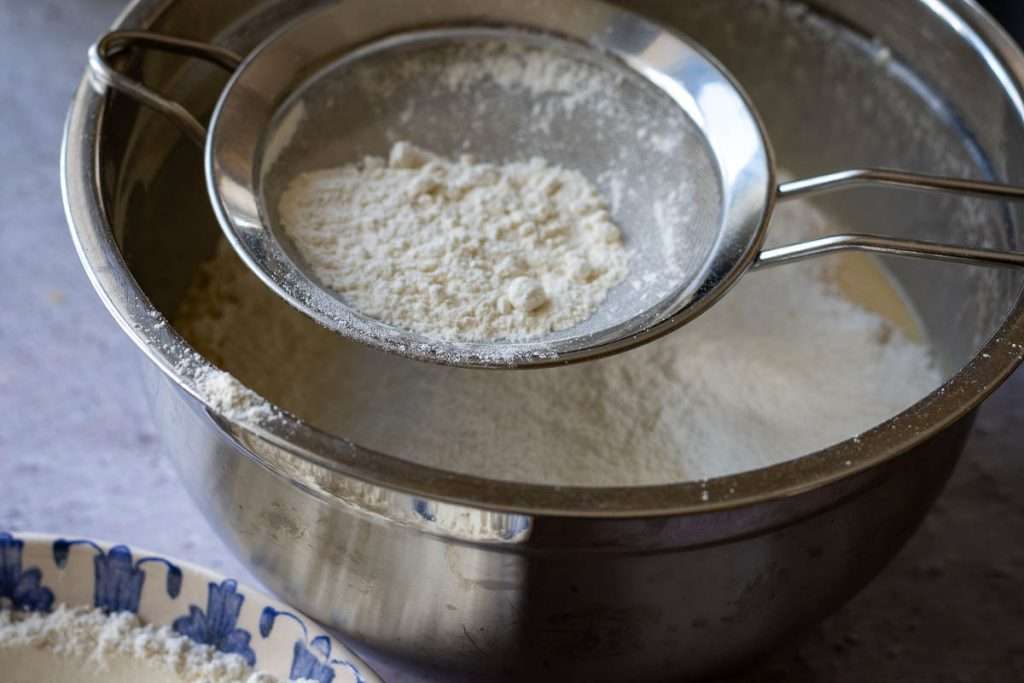 Sifting the dry ingredients into the wet ingredients.