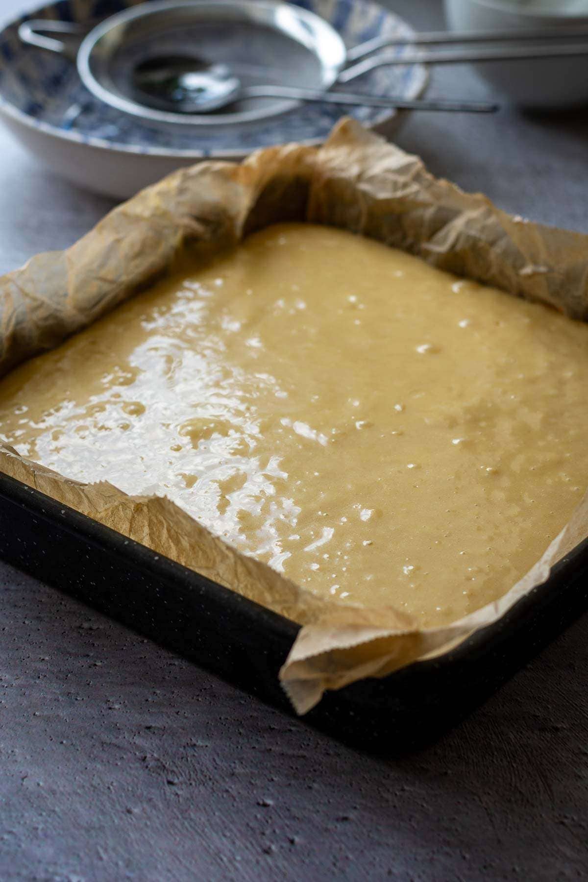 Assembled grapefruit cake in a s aquare tin ready to go into the oven.