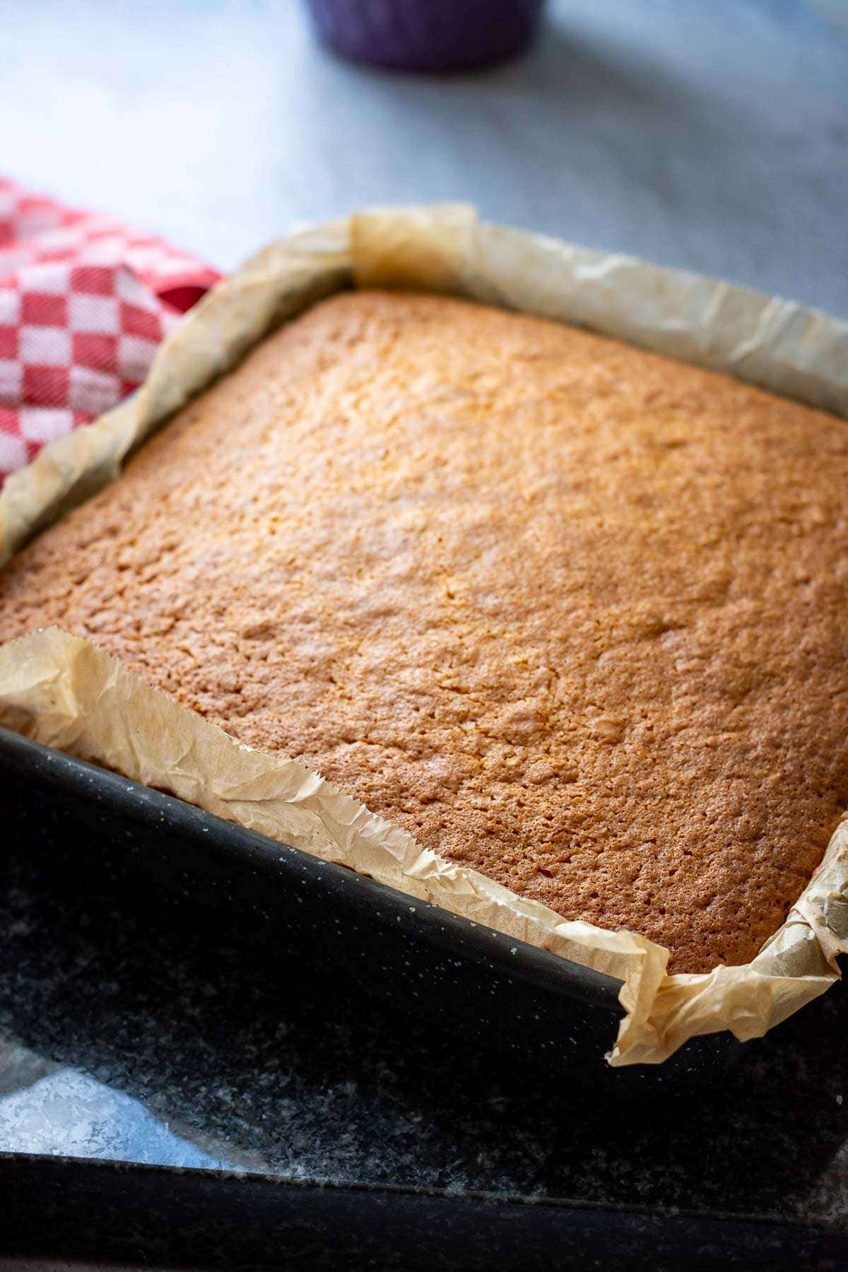Cooked but not flipped grapefruit cake in a square tin.
