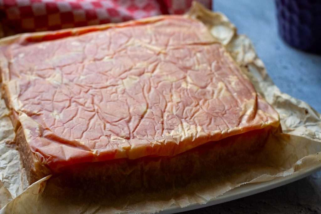 Inverted grapefruit cake on a large plate with parchment paper still on top.