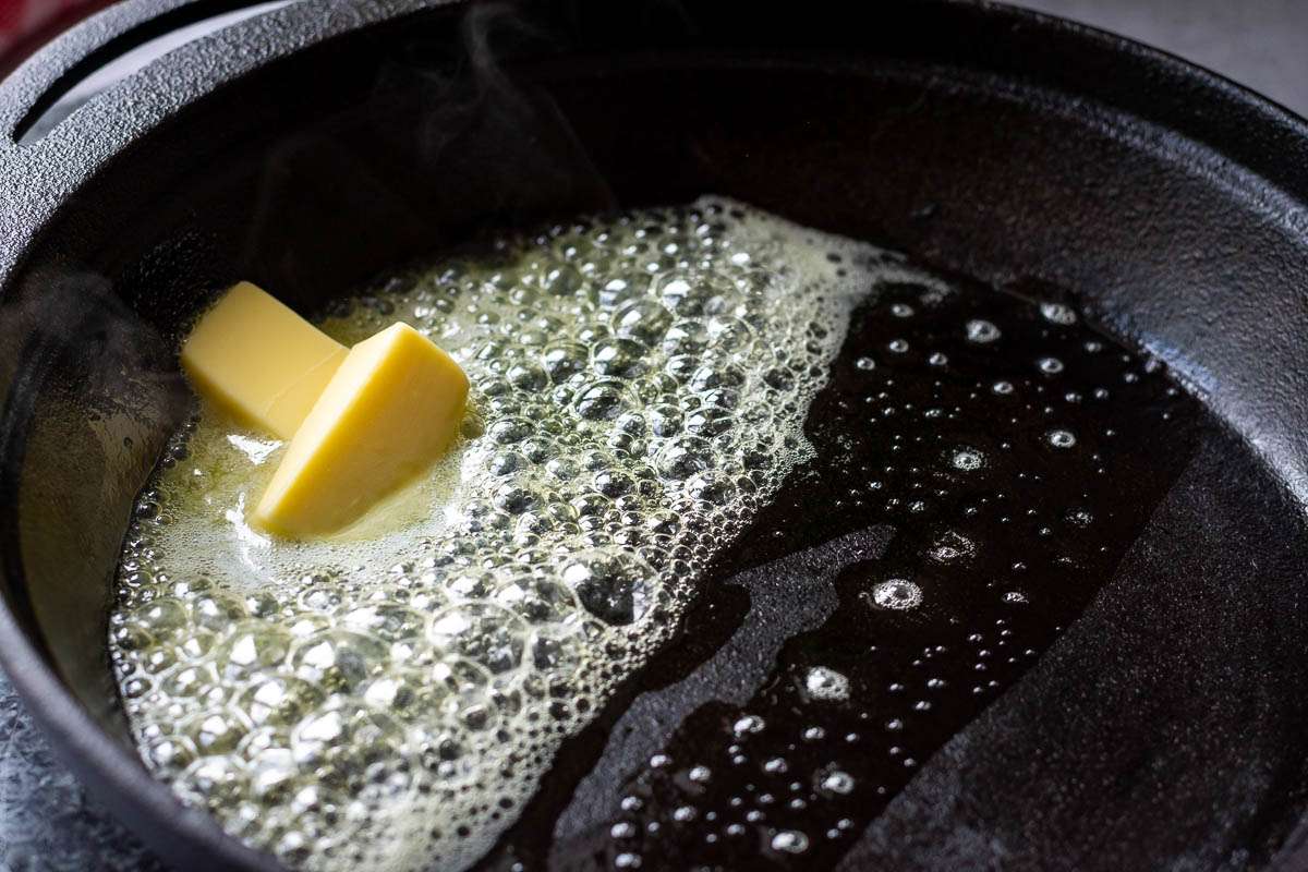Butter melting in a preheated cast iron skillet.