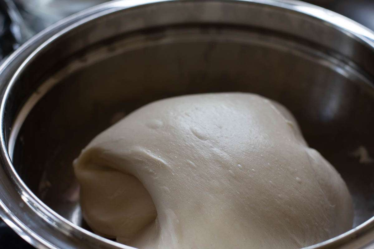 Coil folded sourdough in a metal mixing bowl.