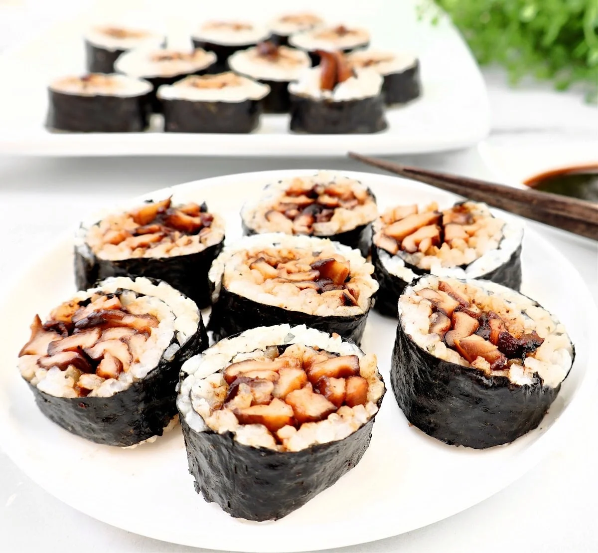 Shiitake mushroom sushi rolls on a white plate.