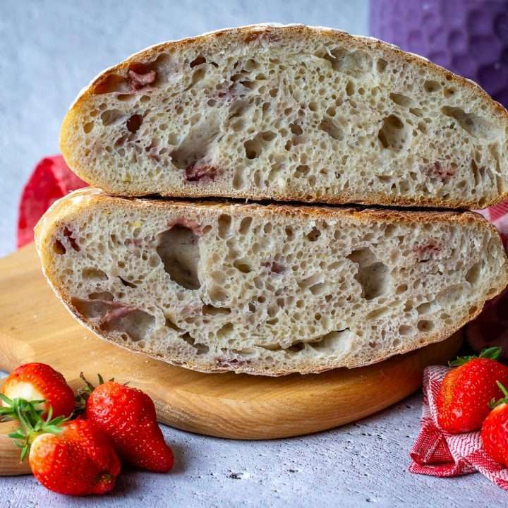 Open crumb of fresh strawberry sourdough bread cut in half.