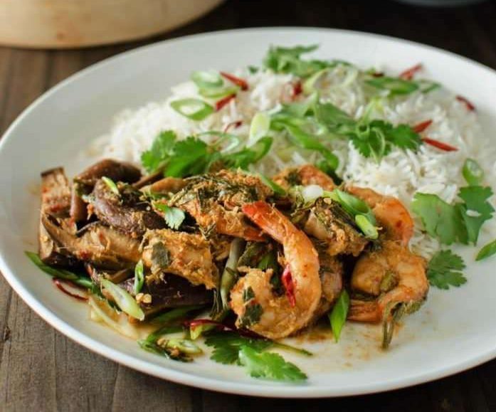 Shrimp and mushroom on a white plate with rice.