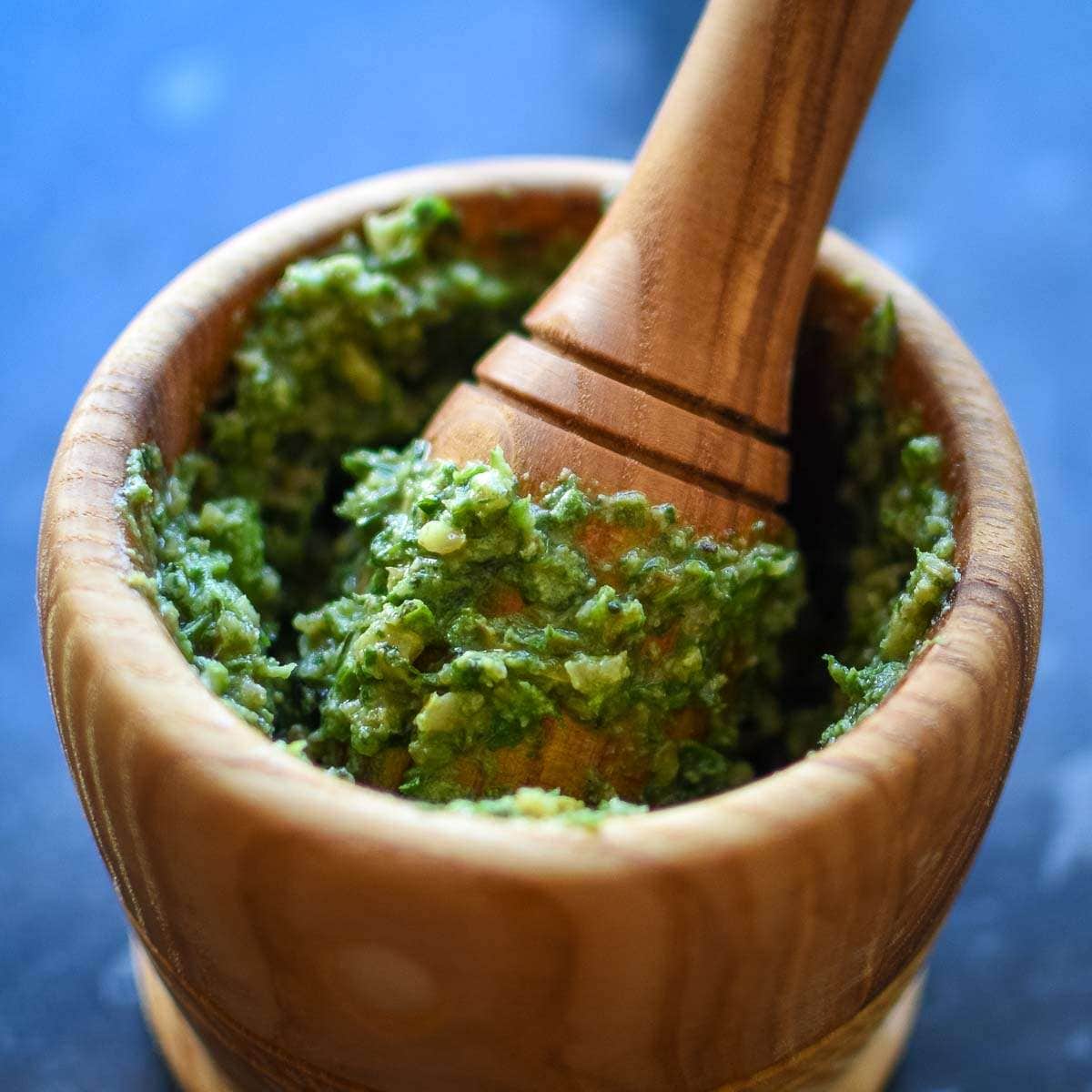 Pesto With Walnuts, Basil and cheddar in a pestle and mortar.