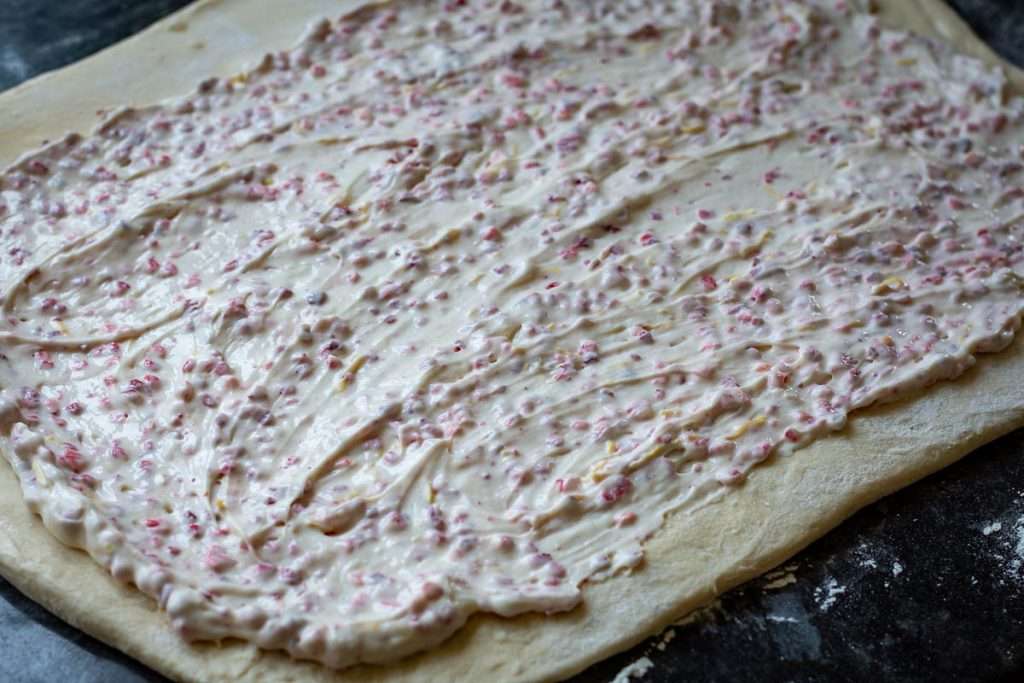 Strawberry cream cheese mixture spread across rolled out dough.