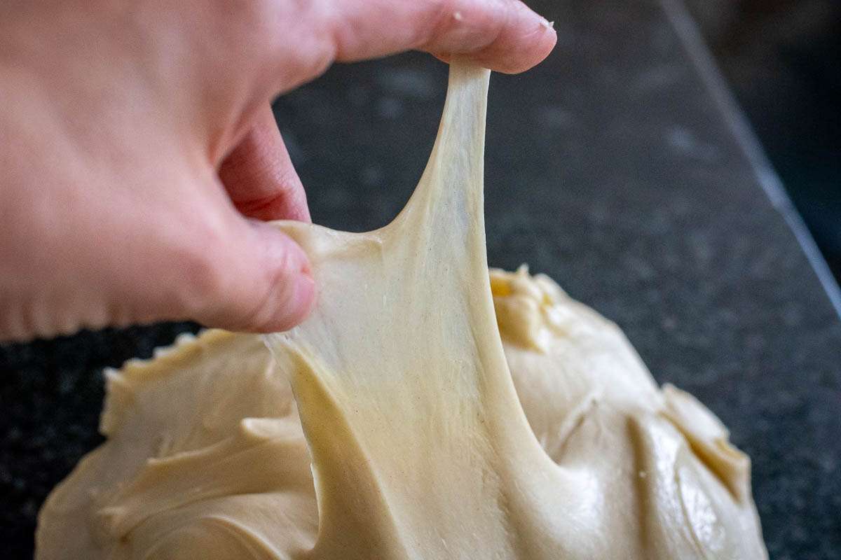 Stretching the dough thinly to show windowpane effect.