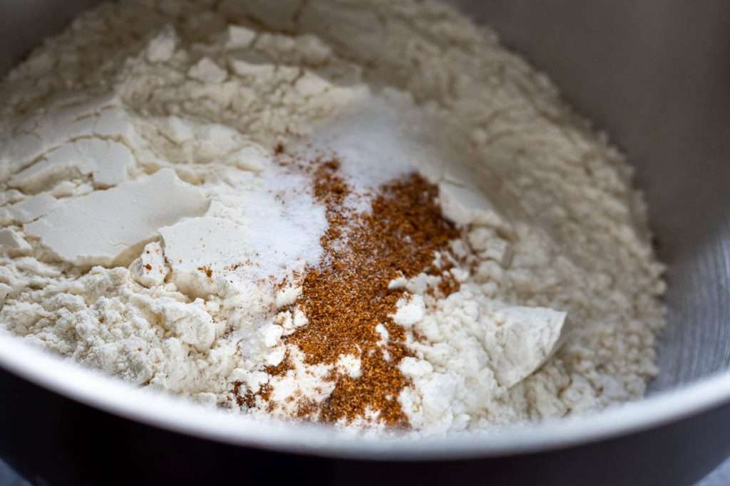 Dry ingredients mixed in a bowl of a stand mixer for sourdough pumpkin bread.