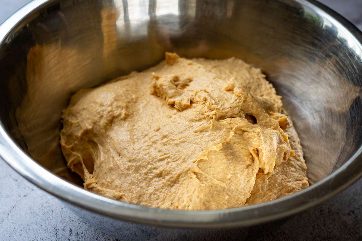 Pumpkin sourdough dough in a metal bowl.