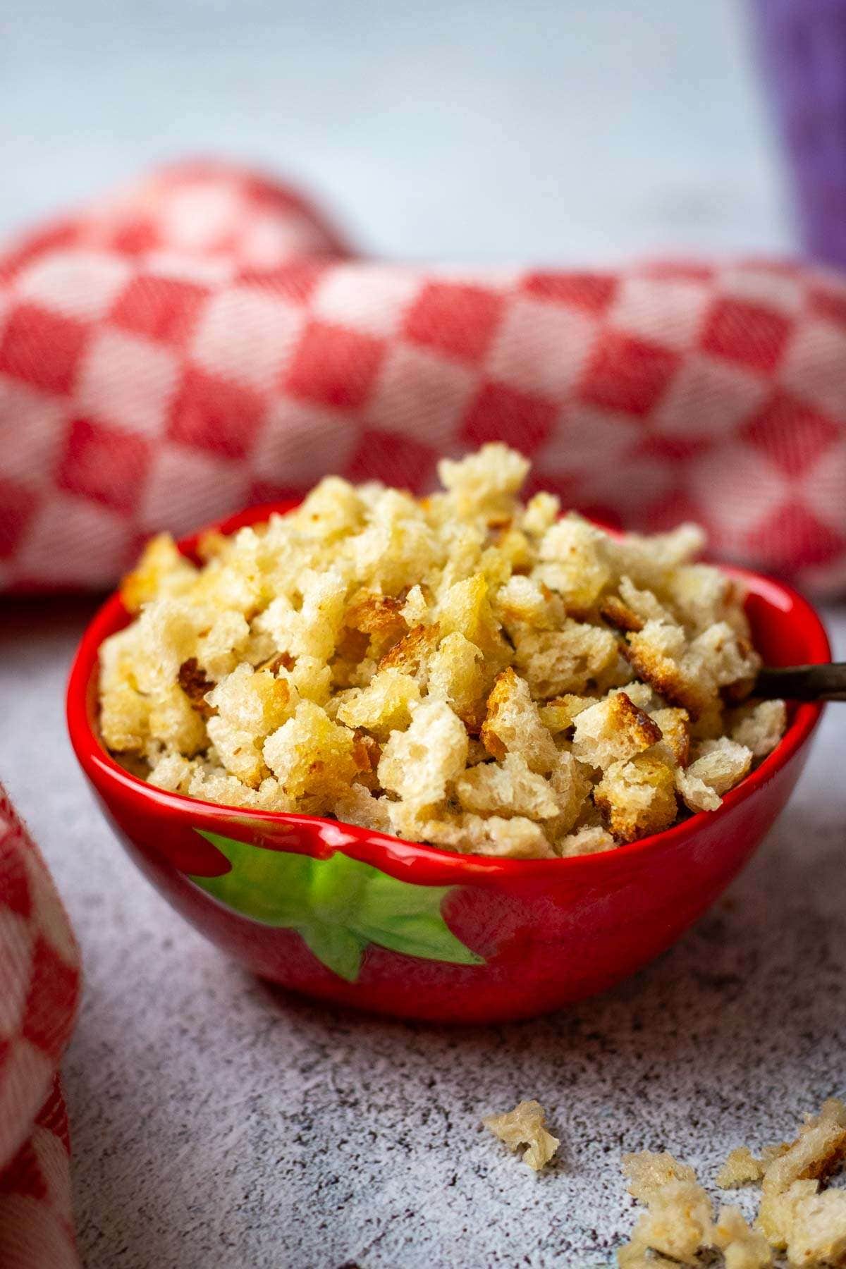 Coarse sourdough breadcrumbs in a small red bowl.