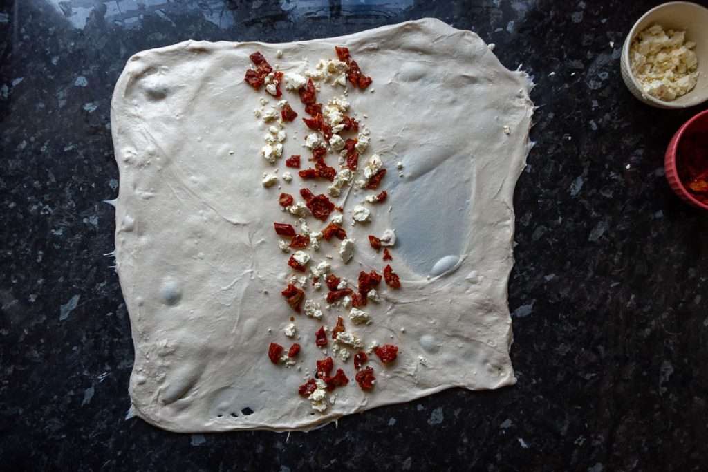 Feta and sundried tomatoes being laminated into the sourdough.