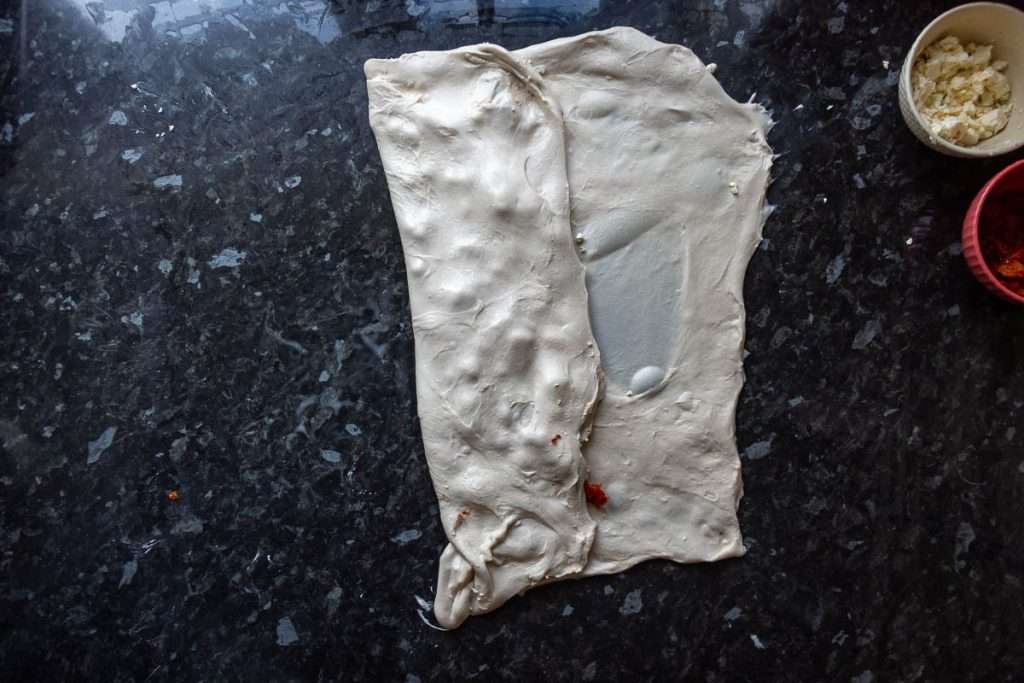 Feta and sundried tomatoes being laminated into the sourdough.