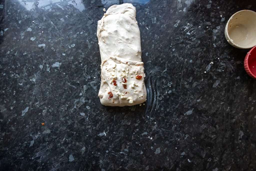 Feta and sundried tomatoes being laminated into the sourdough.