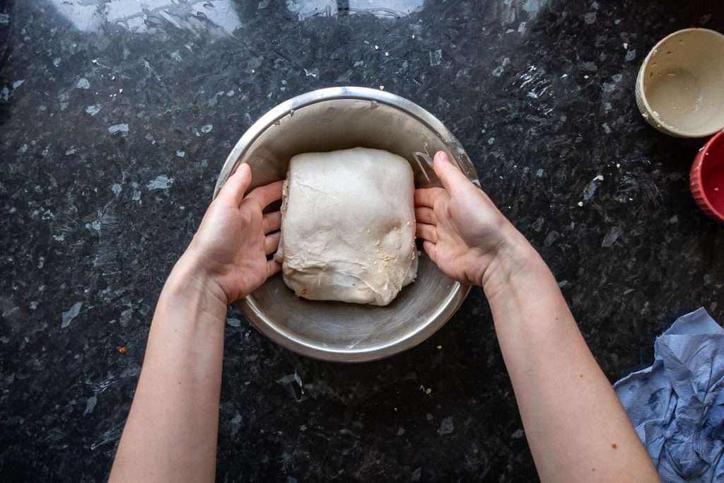 Placing the laminated sourdough parcel into a large mixing bowl.